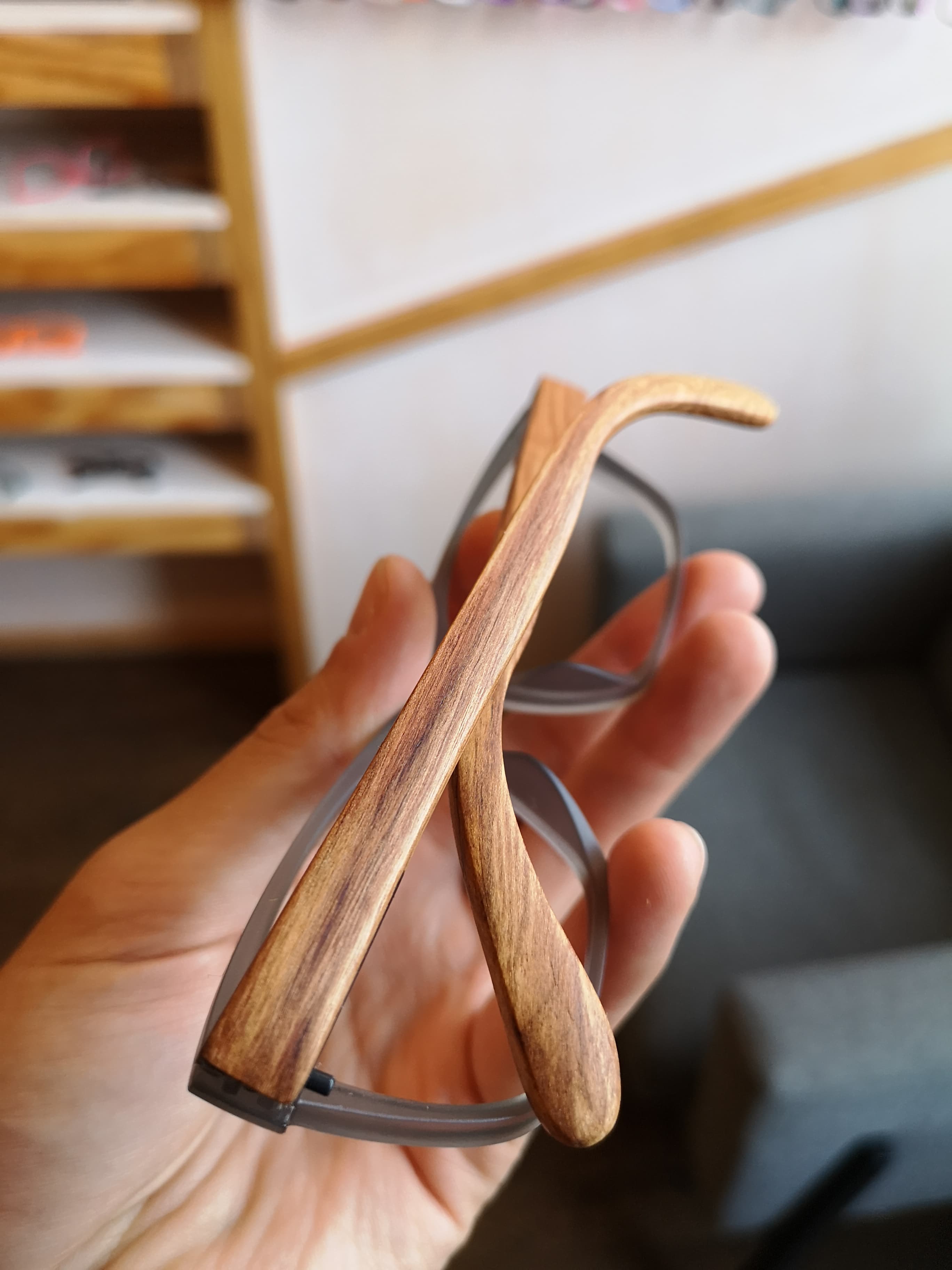 Portrait view of gray eyeglasses with naturally striped rosewood temples