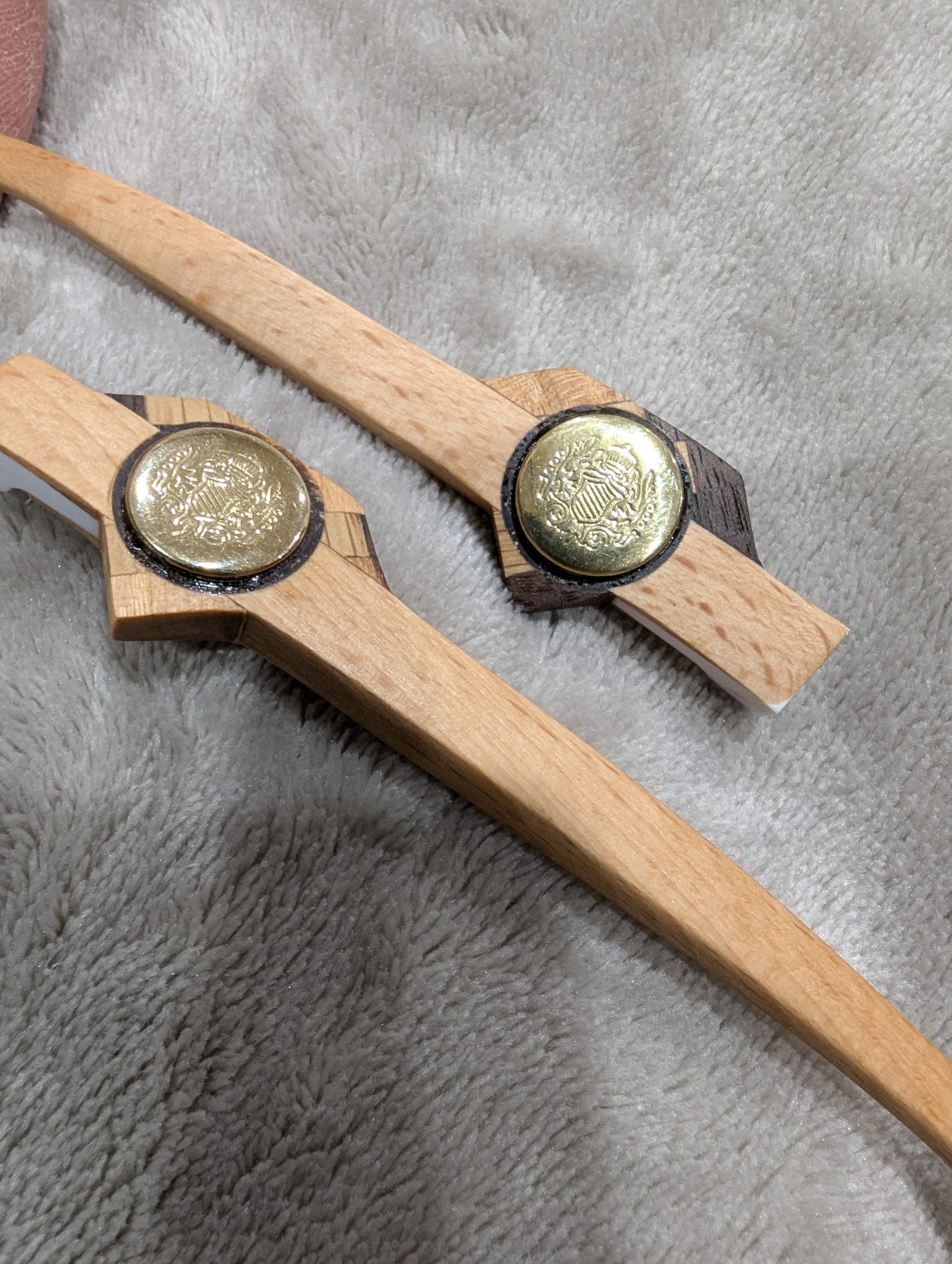 Forest green upcycled material eyeglass frames with beech wood temples, each set with a round brass medallion